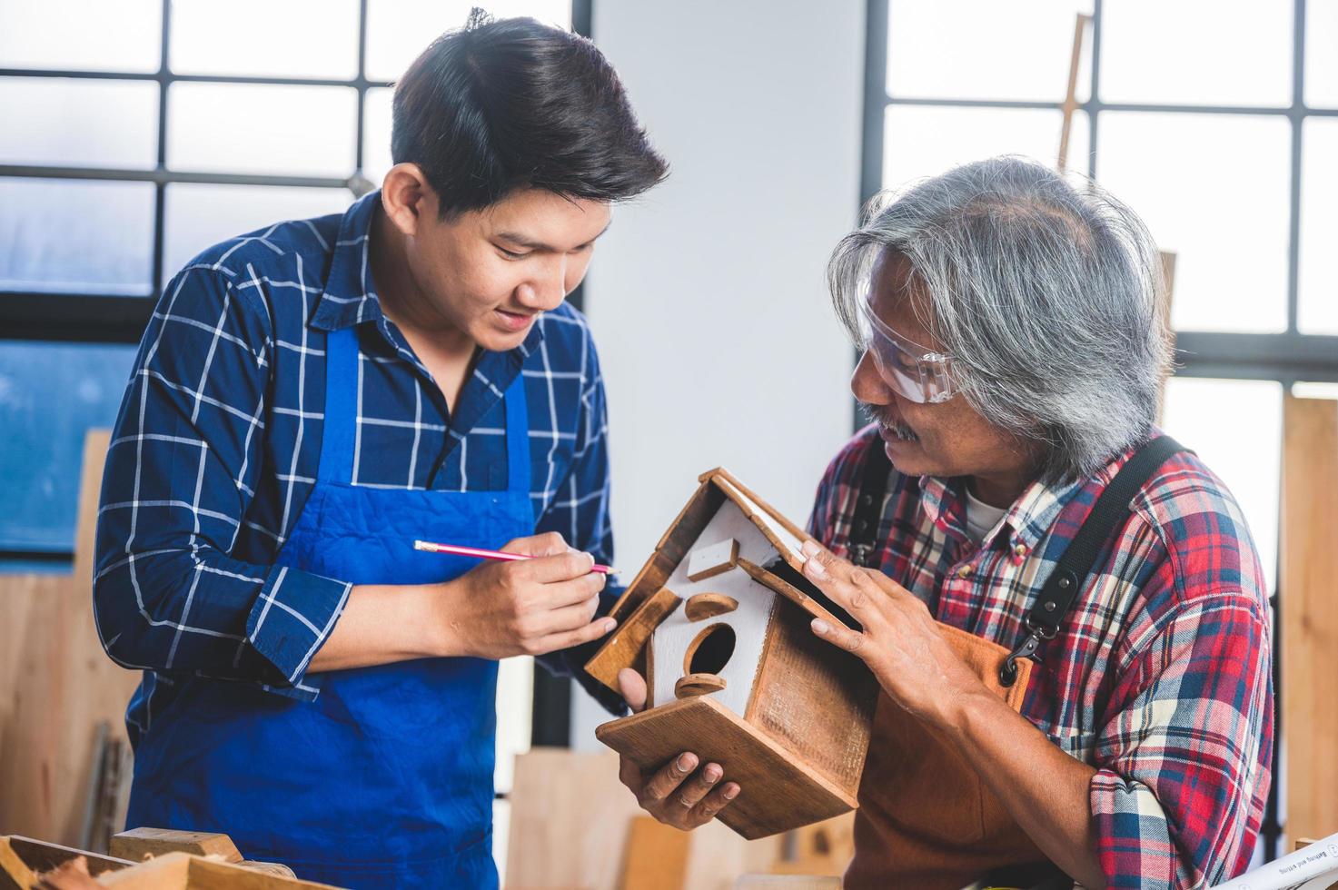 homens pintando uma casa de passarinho foto