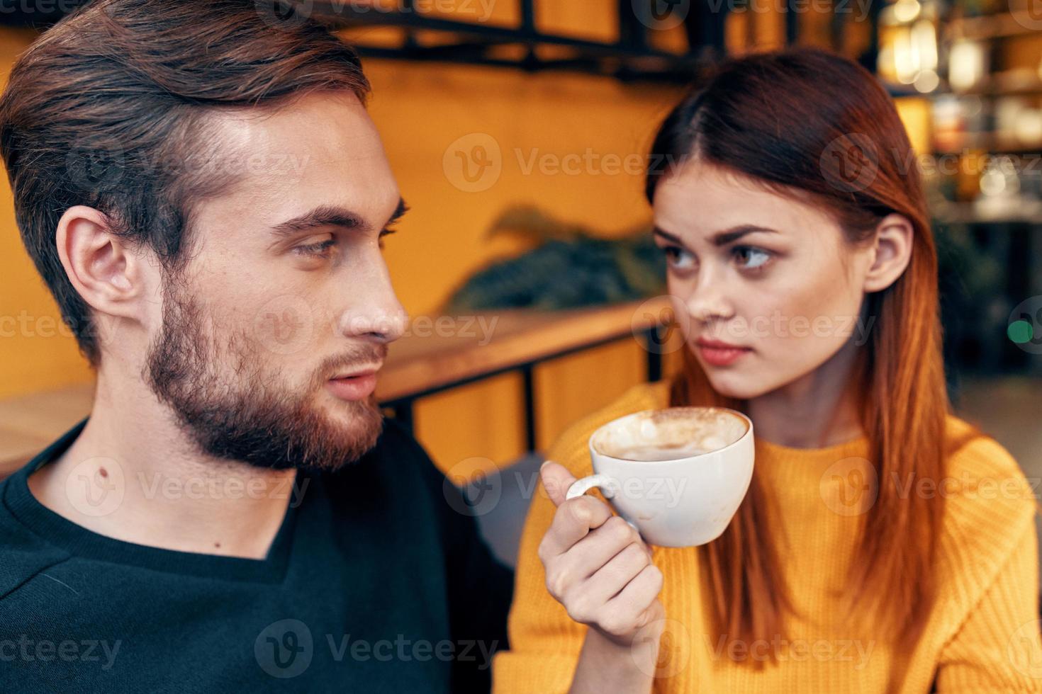 uma mulher dentro uma suéter e uma homem dentro uma cafeteria uma copo do café casal dentro amor amigos família foto