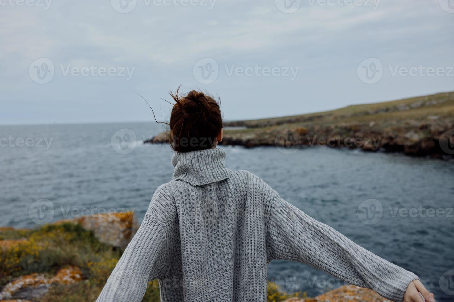 lindo mulher blusas nublado mar admirando natureza inalterado foto