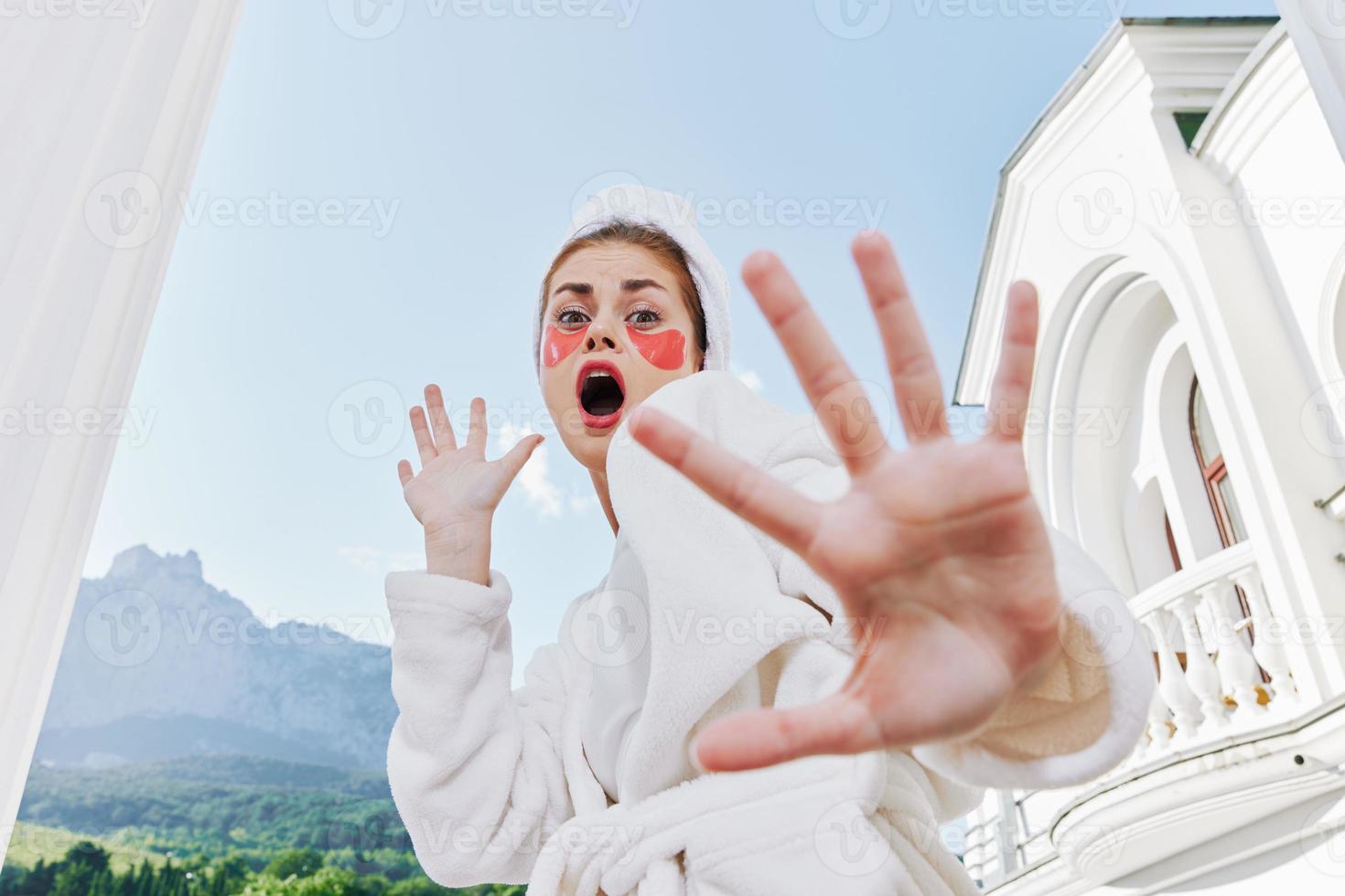 alegre mulher dentro uma branco roupão em uma fundo do montanhas manhã natureza foto