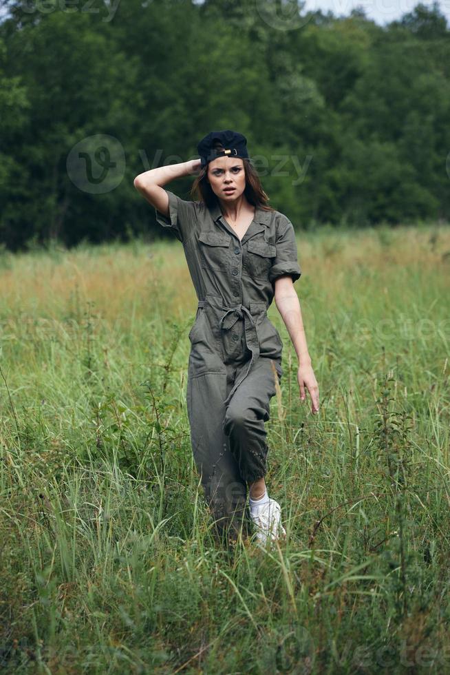 mulher retrato em natureza dentro uma verde macacão, uma Preto andar boné foto