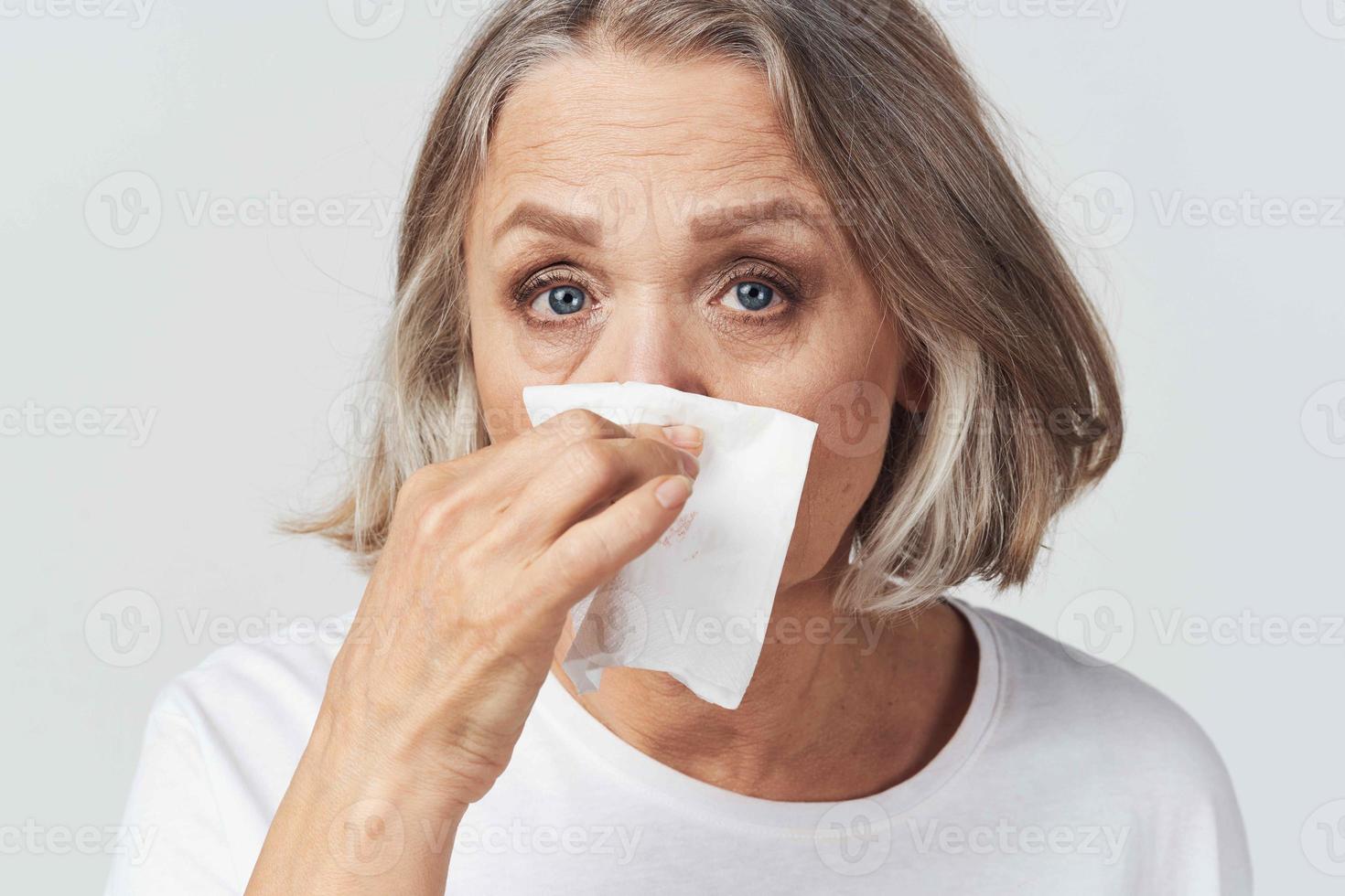 idosos mulher escorrendo nariz lenço frio foto