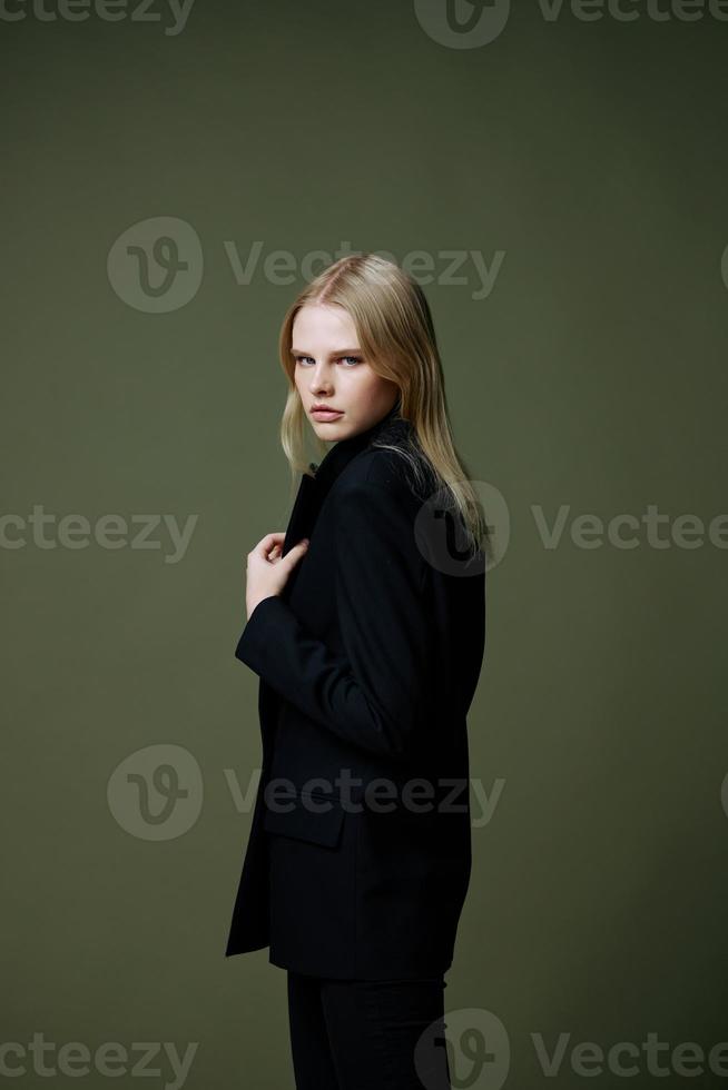 uma conceito para mercados e roupas marcas. comprimento total retrato do uma Loiras segurando uma Jaqueta colarinho posando em uma verde fundo dentro a estúdio foto