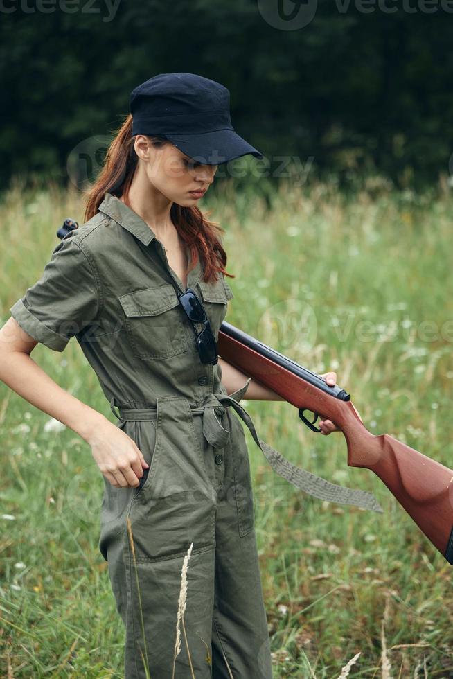 mulher em ao ar livre verde macacão segurando fresco ar dentro braços armas foto