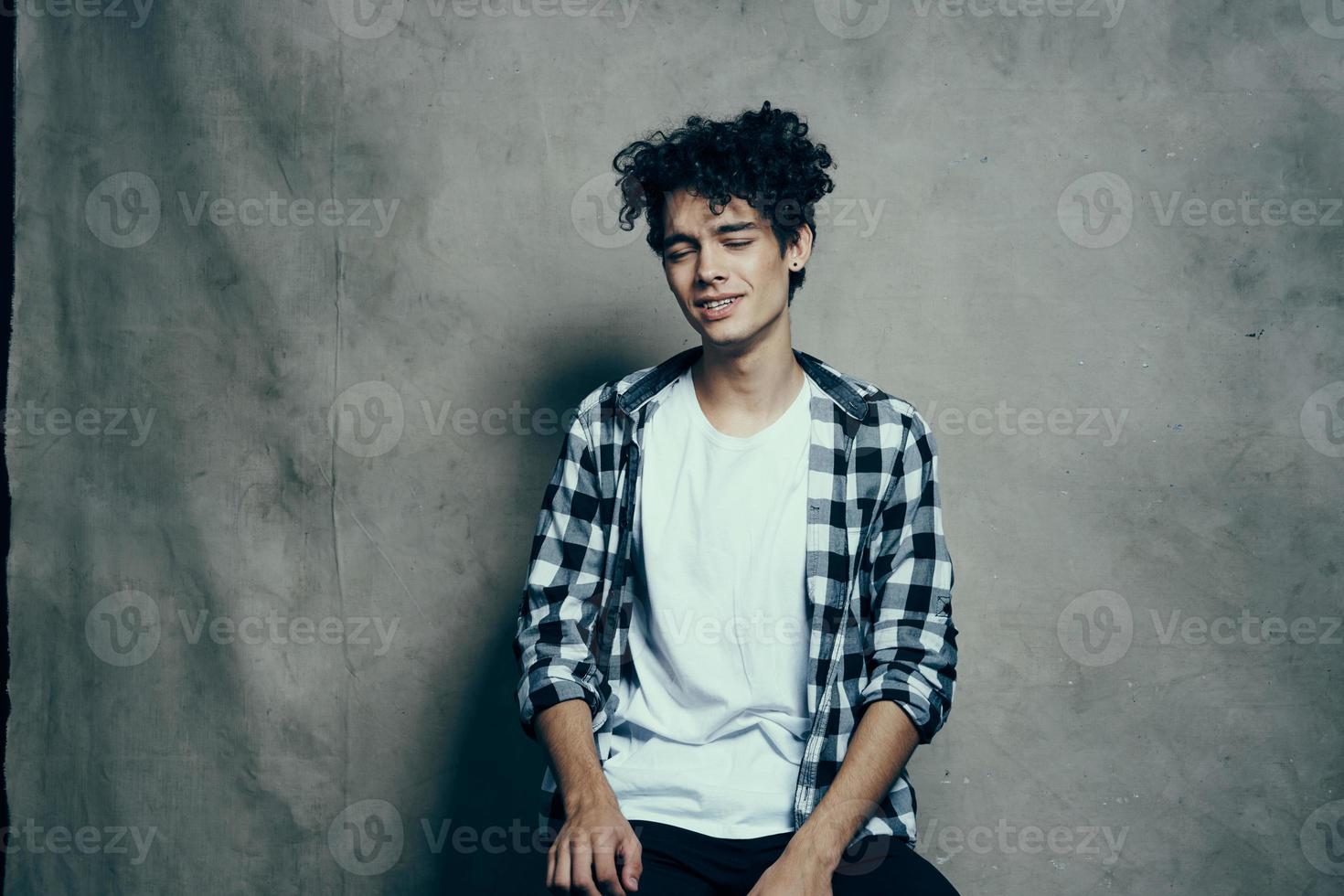 alegre cara encaracolado cabelo xadrez camisa estúdio cinzento fundo foto