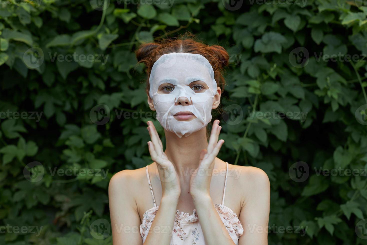 lindo mulher anti-rugas mascarar mãos perto a face e uma luz camisa rejuvenescimento folhas dentro a fundo foto