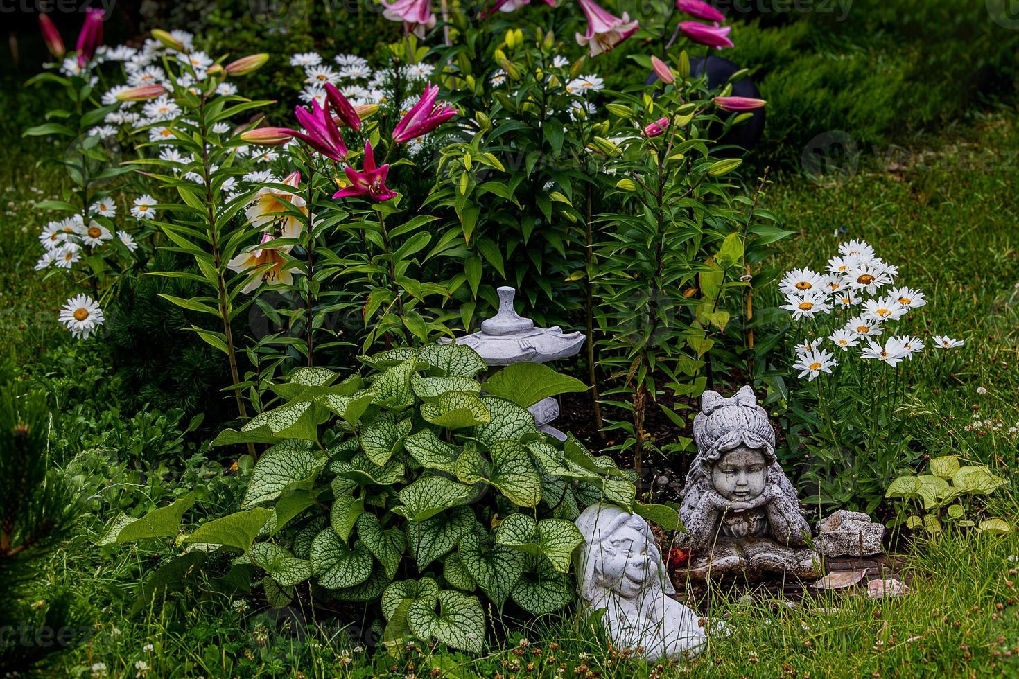 verde jardim com flores e gesso estatueta natural fundo foto