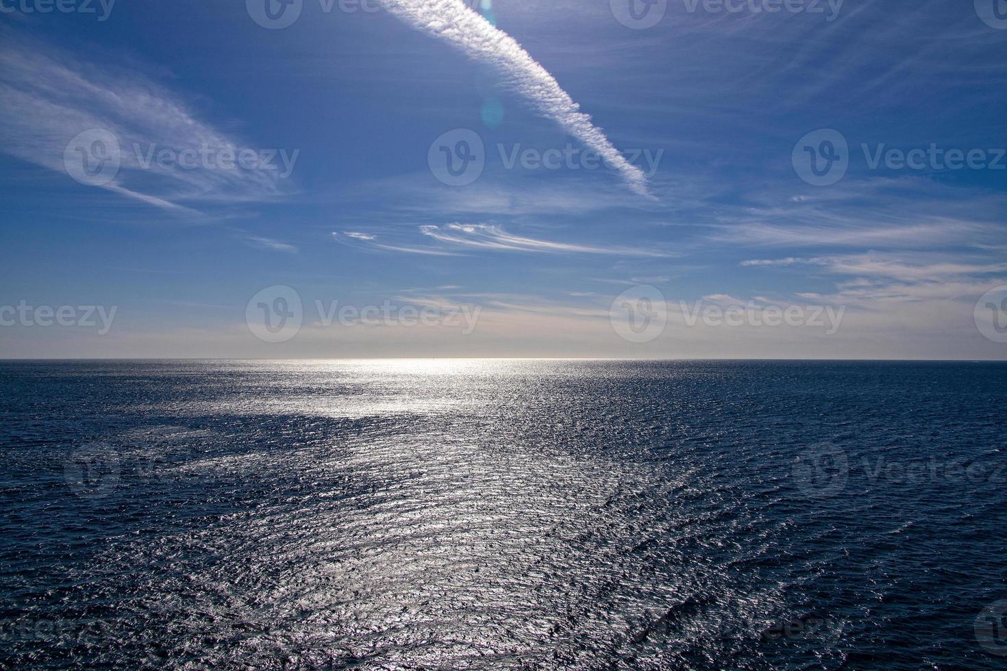 mar panorama em uma ensolarado dia com azul céu e água e uma Navegando navio foto