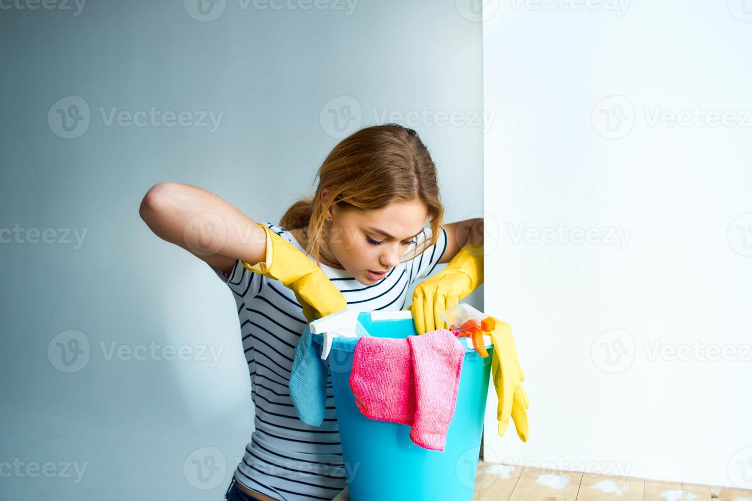 mulher com uma balde do limpeza suprimentos perto a janela levando Cuidado do a casa foto