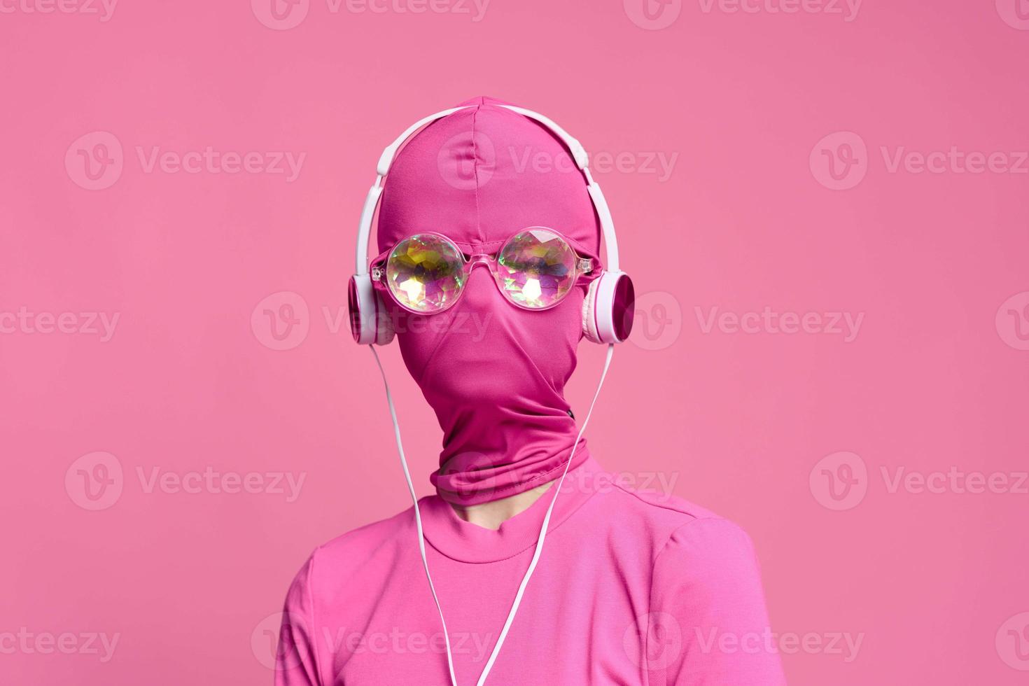 mulher arte batidas conceptual retrato em brilhante Rosa cera vestindo brilhante néon copos, Rosa mascarar e fones de ouvido foto