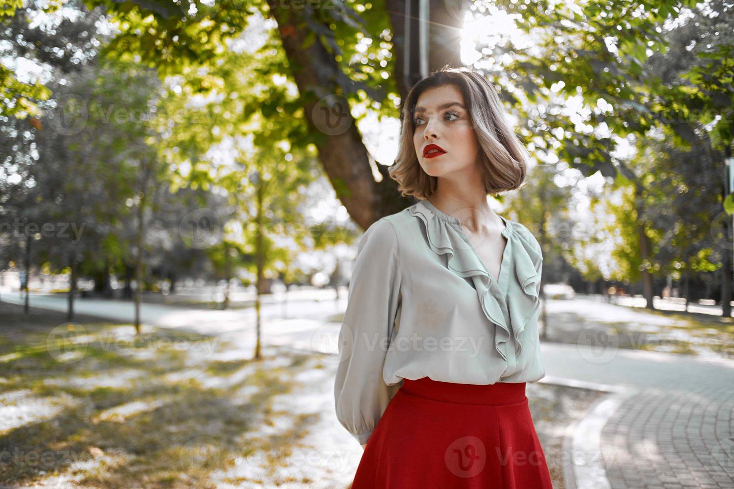 mulher dentro vermelho saia anda em dentro a parque árvores estilo de vida foto