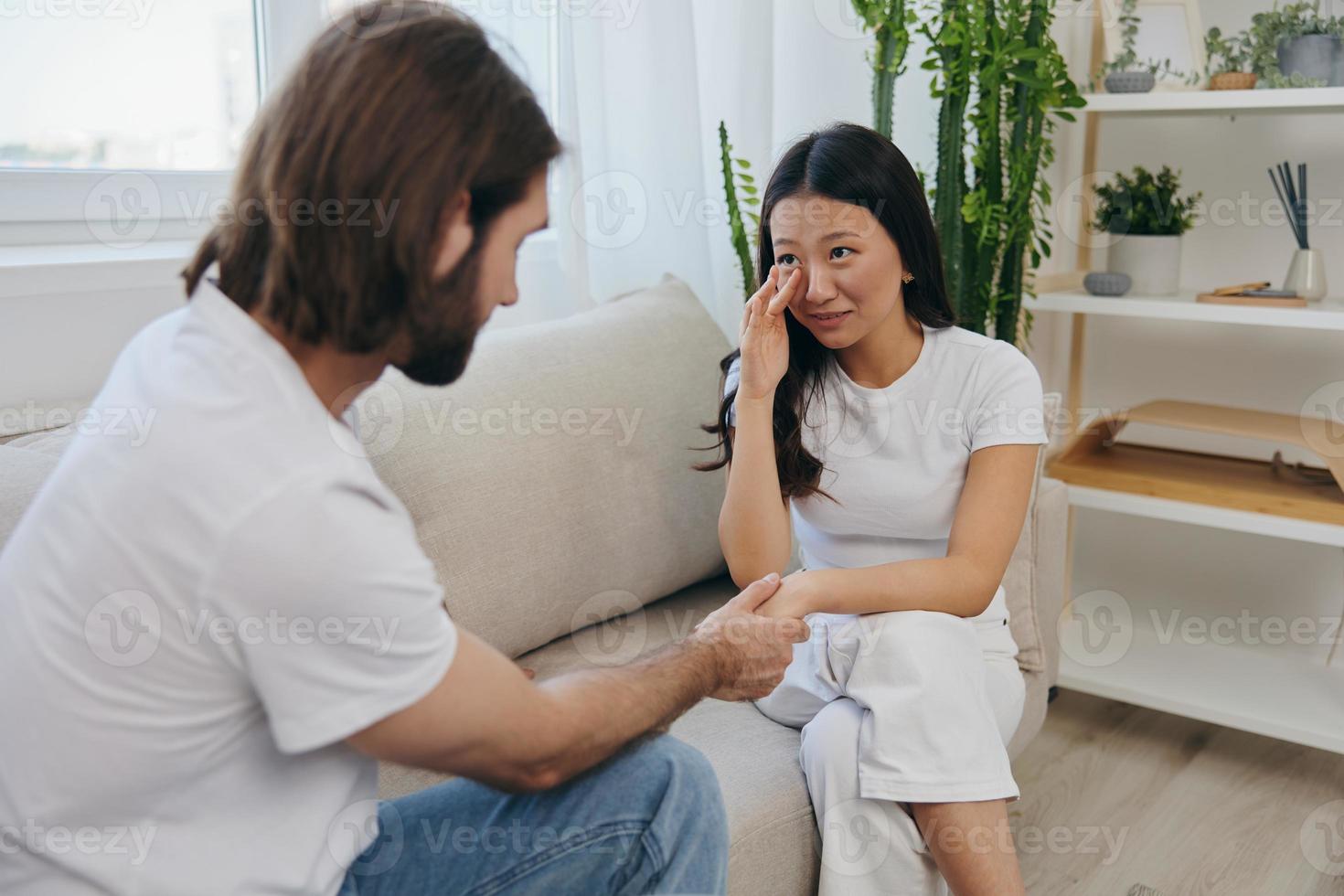 a ásia mulher é triste e chorando com dela masculino amigo às lar. estresse e mal entendido dentro uma relação entre dois pessoas foto