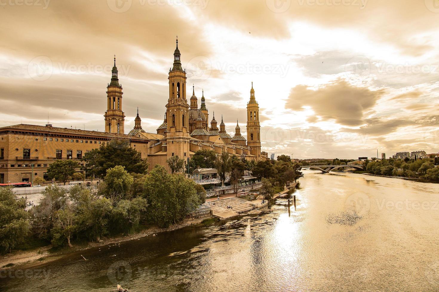 panorama a partir de a espanhol cidade do Saragoça com a basílica e a Ebro rio dentro a fundo do a Sol configuração dentro a céu foto