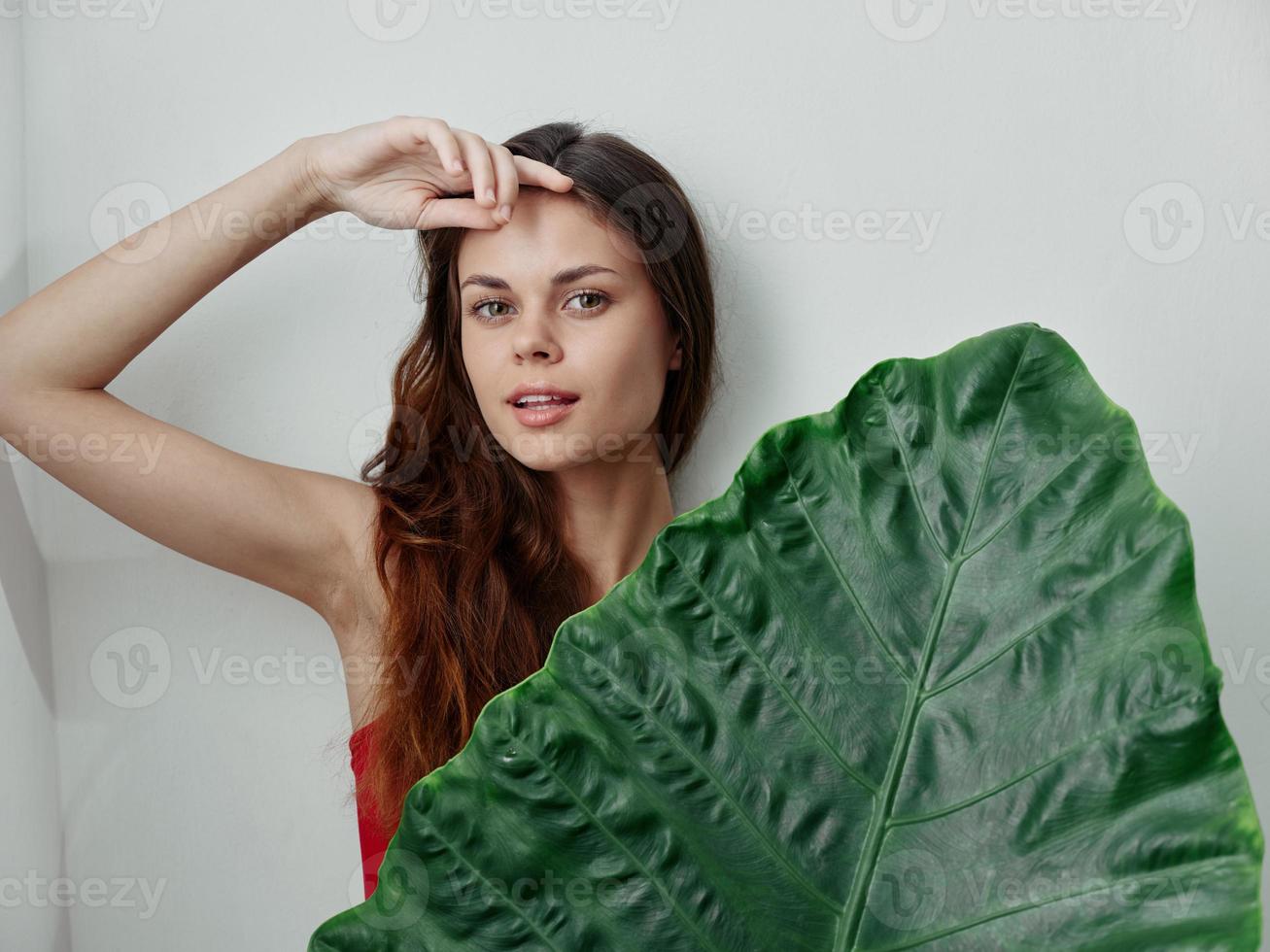 mulher se escondendo atrás Palma folha trópicos isolado fundo foto