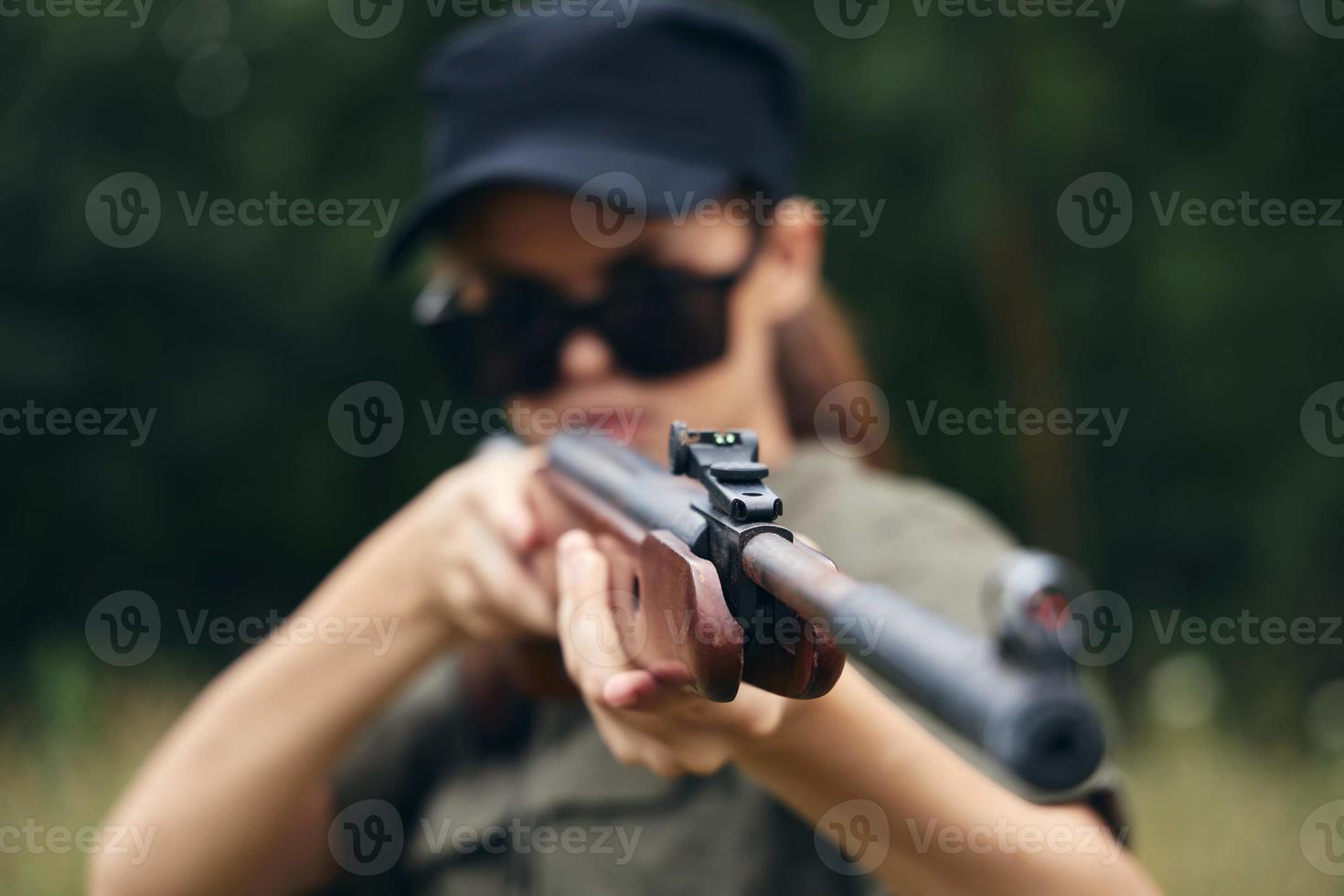 mulher em natureza arma de fogo vista Caçando Preto boné verde foto