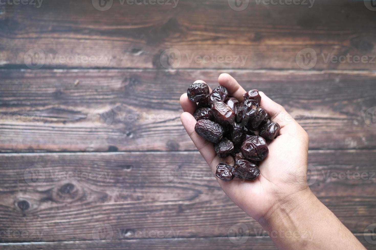 mão segurando frutas de tâmara foto