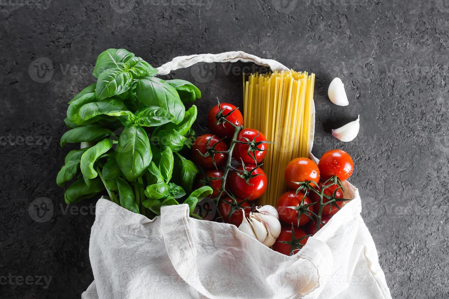 saudável produtos para italiano massa dentro tecido saco em Sombrio mesa. reutilizável saco com mantimentos. foto