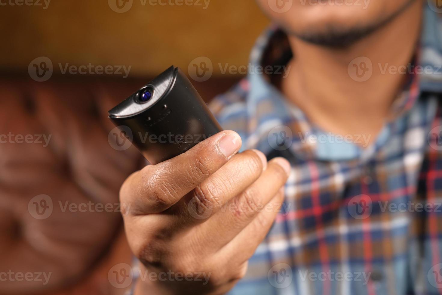 homem segurando o controle remoto da tv foto