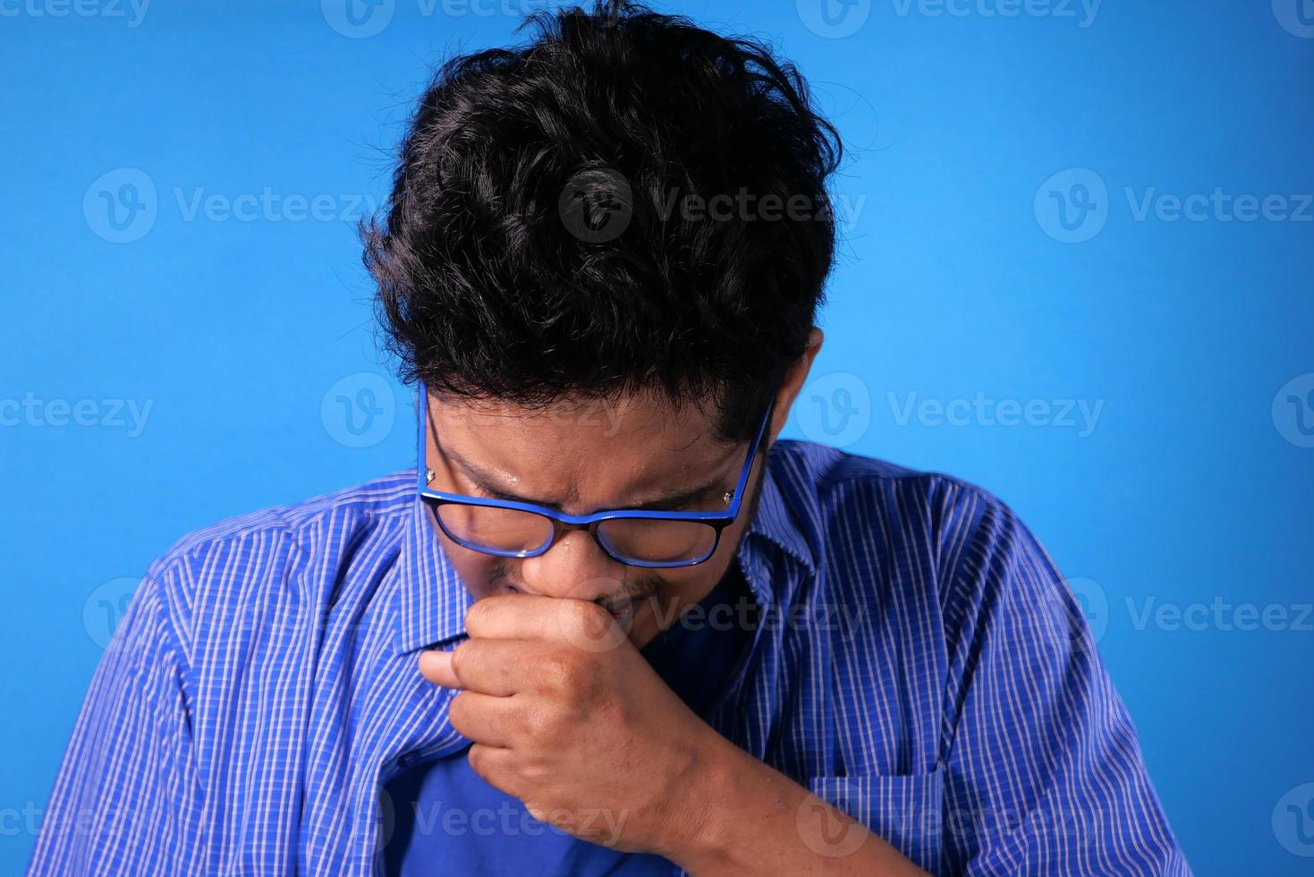 homem doente em vestido casual tossindo, fundo azul foto