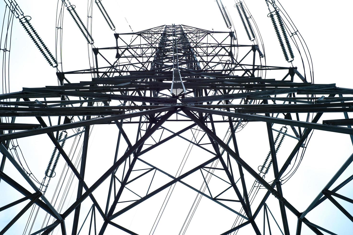 vista de alto ângulo da torre de eletricidade de alta tensão em um dia ensolarado com fundo de céu claro foto