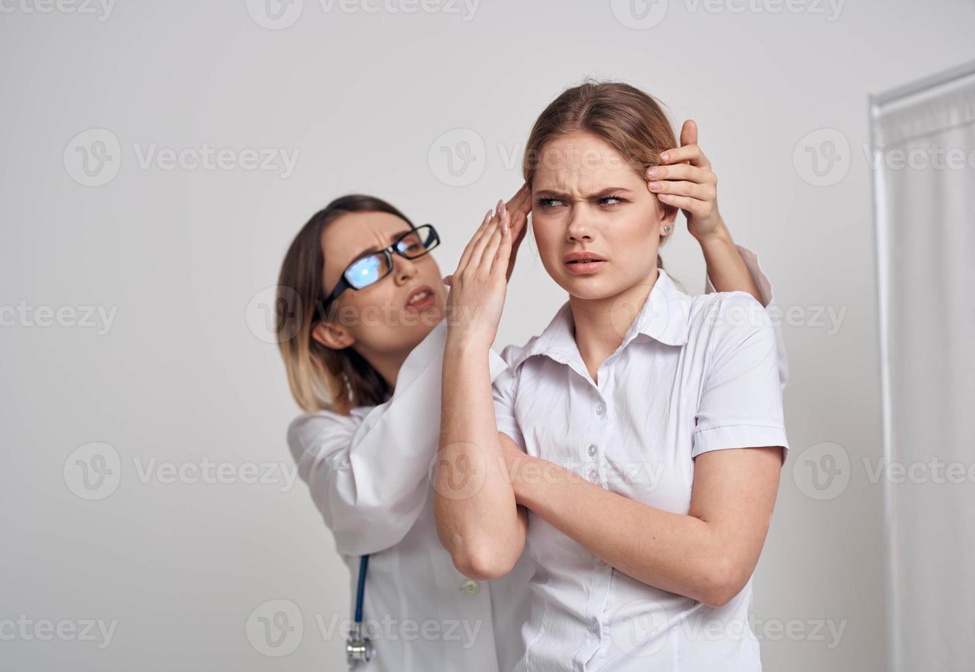 profissional médico mulher dentro óculos toques a cabeça do a paciente em uma luz fundo foto