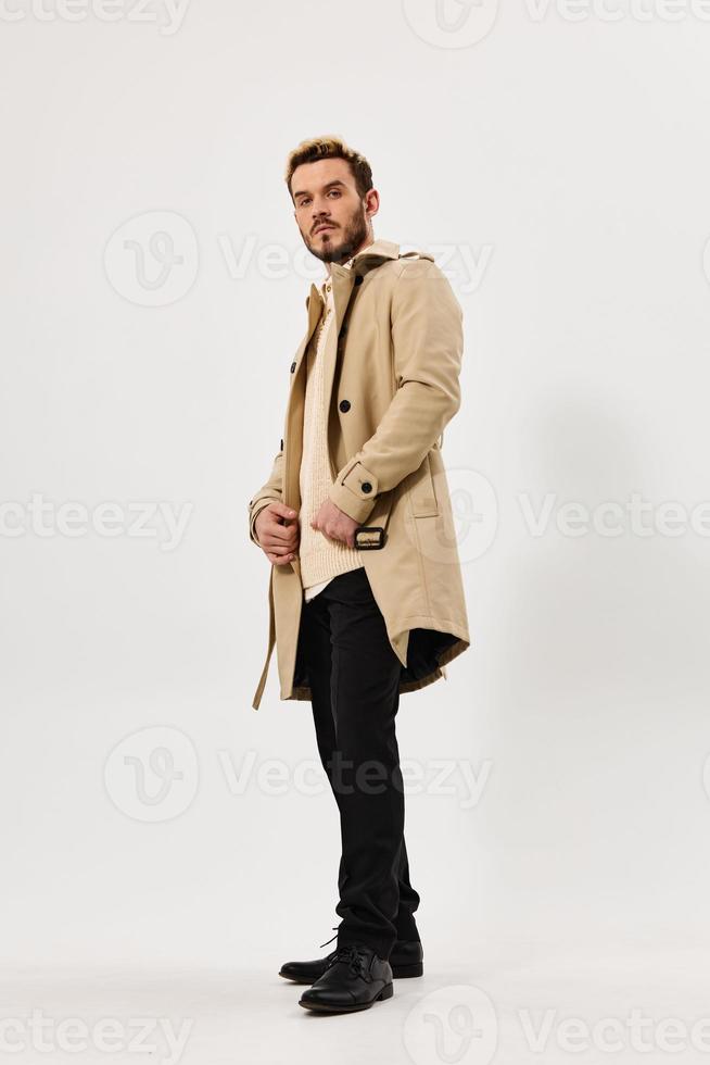 homem dentro bege casaco moda moderno estilo lado Visão cheio comprimento foto