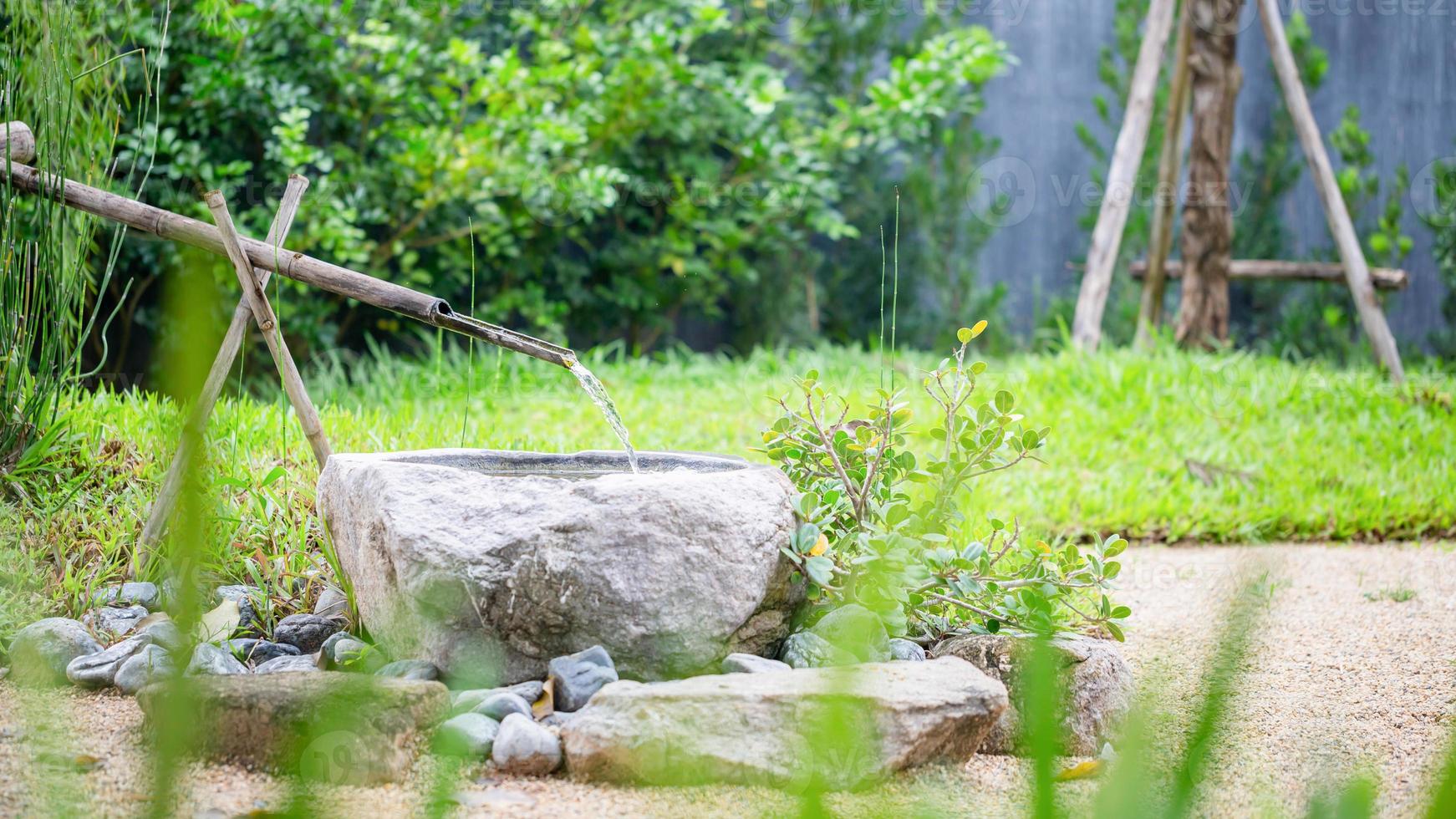 bambu fonte dentro japonês jardins borrado fundo, tradicional ásia bambu fonte com água corrente foto