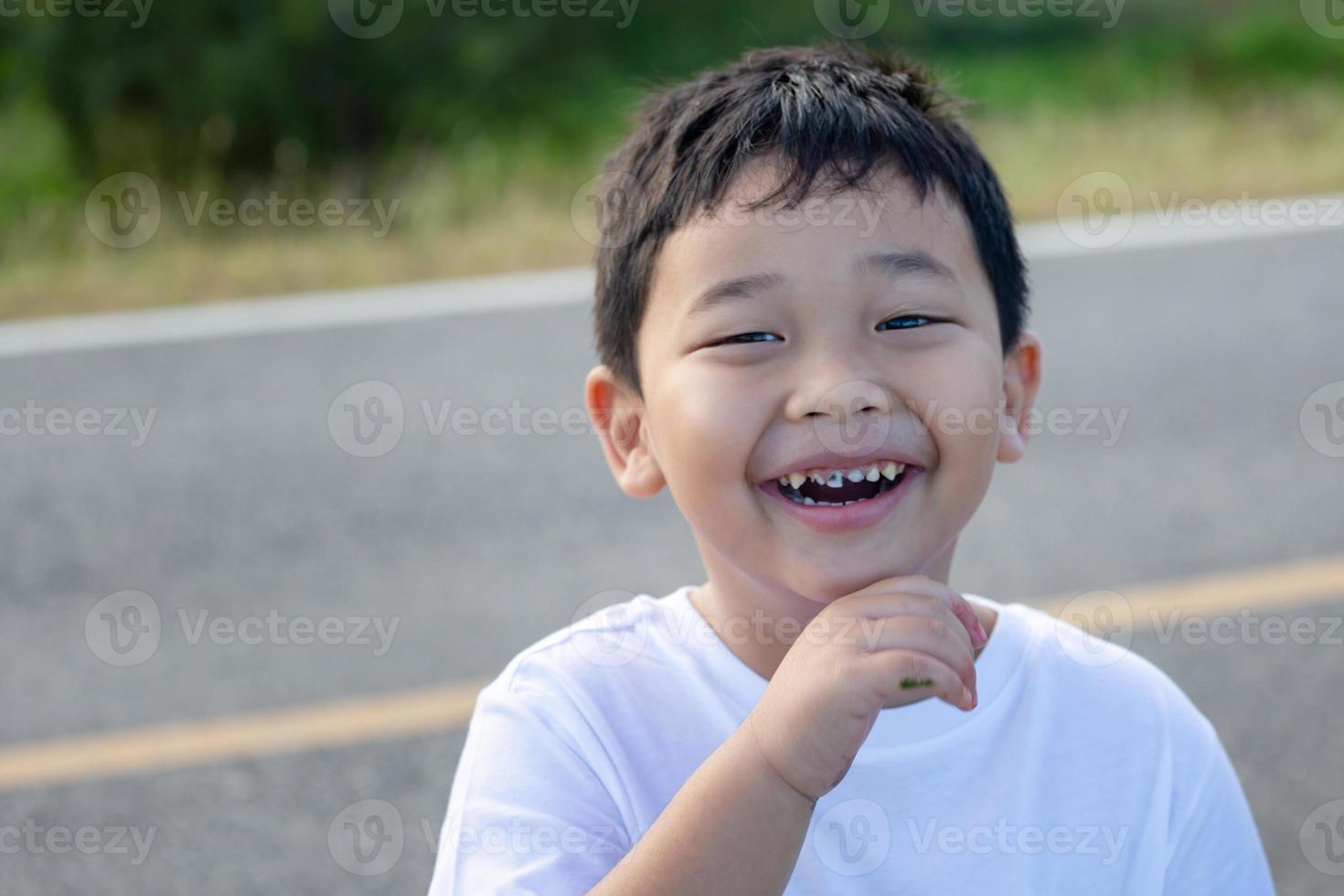 sorridente criança Garoto com borrado fundo, alegre criança Garoto jogando ao ar livre foto