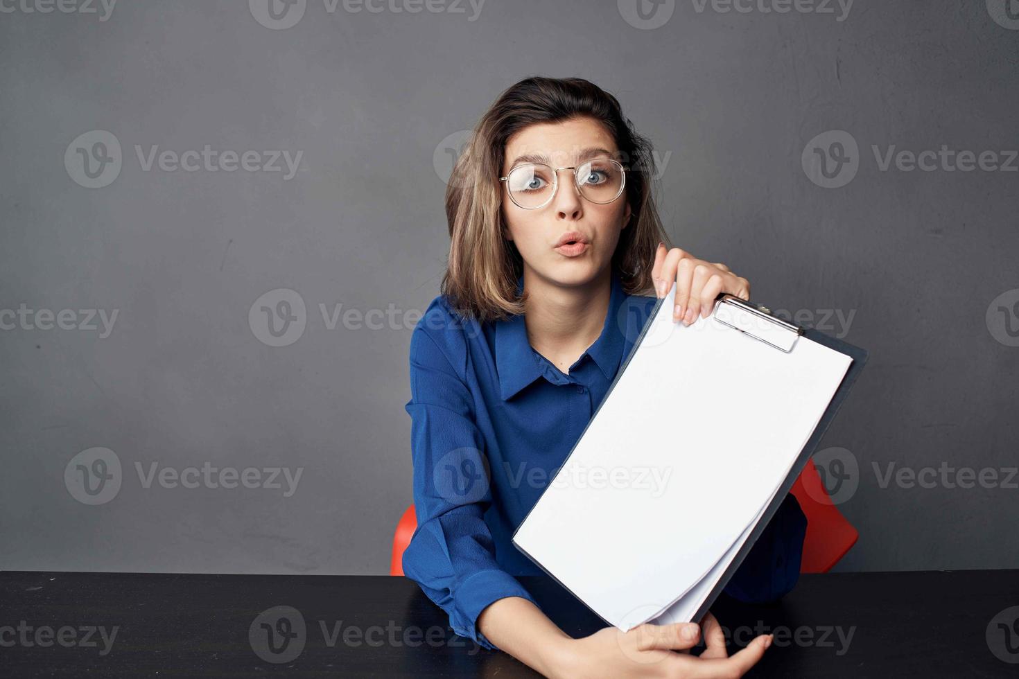 o negócio mulher vestindo óculos senta às a mesa em branco Folha cópia de espaço foto