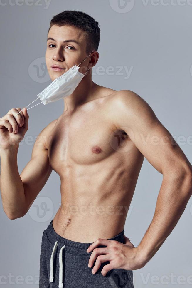 desportivo homem com muscular corpo médico mascarar posando foto