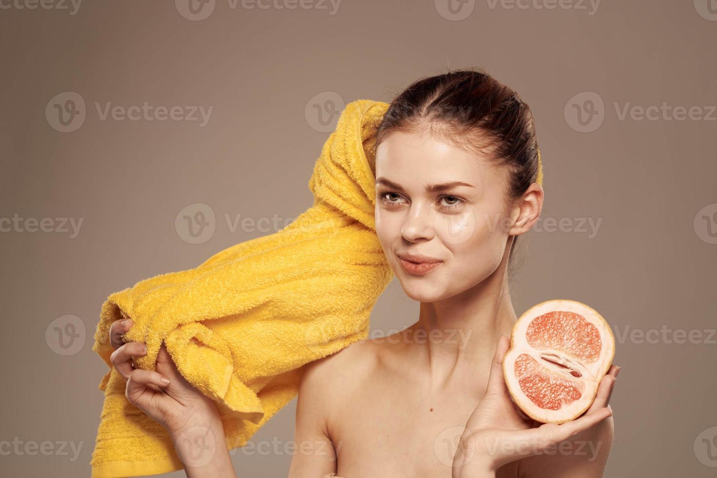 mulher com Toranja dentro dela mão limpar \ limpo pele nu ombros spa saúde tratamentos foto