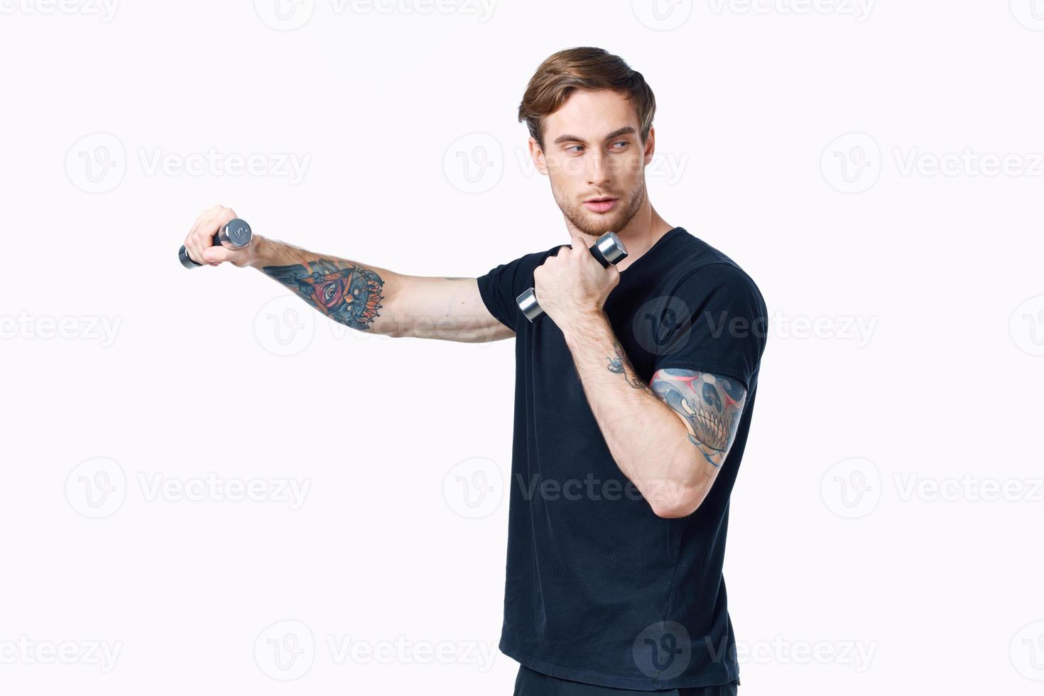 atleta dentro Preto camiseta com halteres dentro mão em branco fundo cortada Visão foto