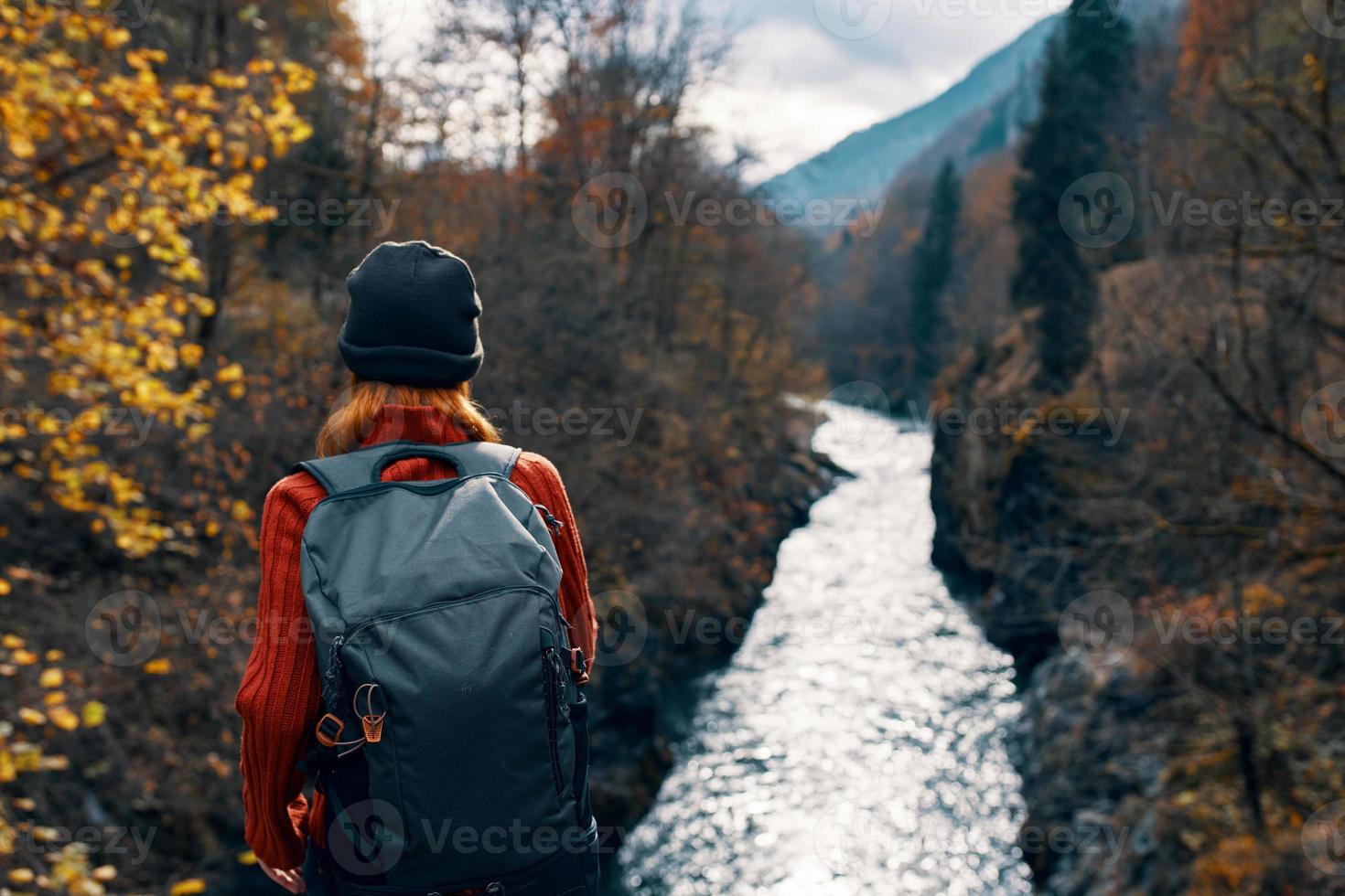 mulher turista mochila rio montanhas outono foto