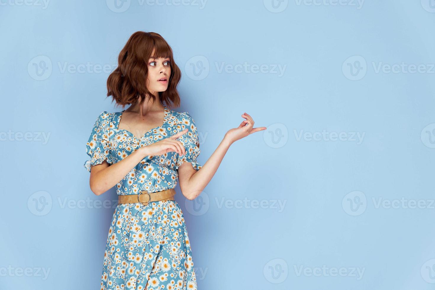 mulher dentro flor vestir parece para a lado pontos dedos para a lado elegante Penteado foto