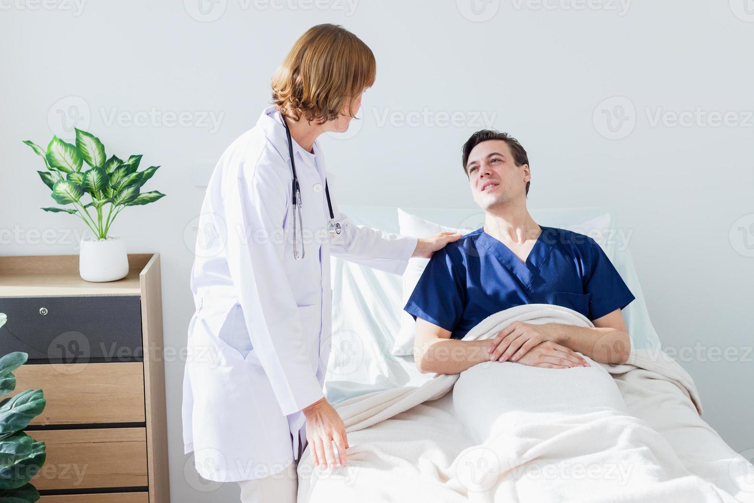 a médico é examinando a paciente dentro a hospital. caucasiano fêmea médico falando para masculino paciente deitado dentro hospital cama. foto