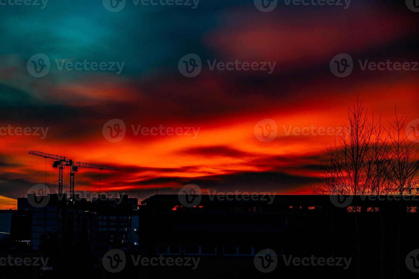 pitoresco panorama com pôr do sol com construção guindastes em a horizonte foto