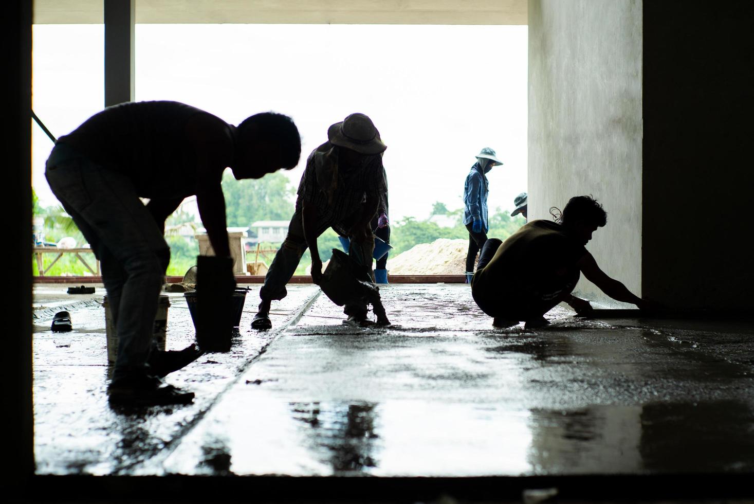 silhueta do grupo de trabalhadores na casa em construção foto