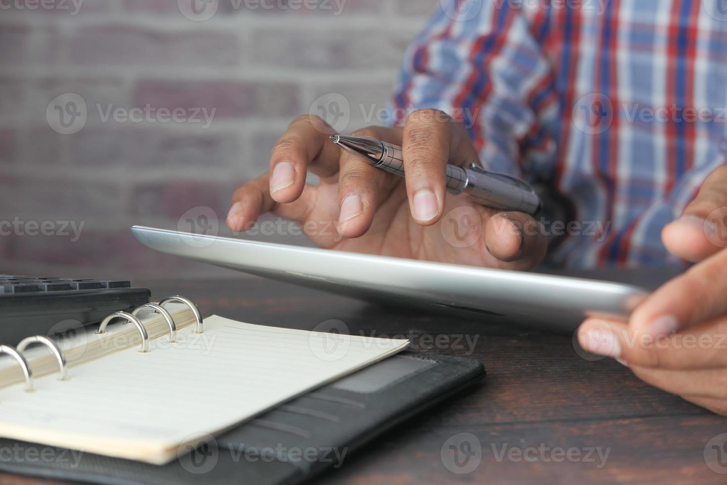 mão do homem balançando no tablet digital foto