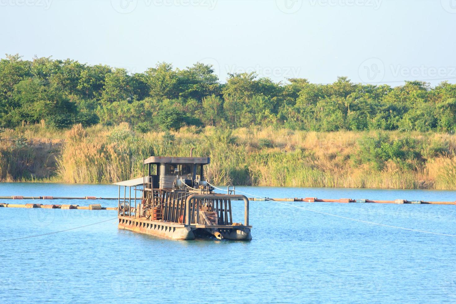 as embarcações de sucção de areia estão transportando areia de tubos de aço em rios profundos para a construção de indústrias como casas, prédios, estradas e muitas outras onde a areia é usada como mistura. foto