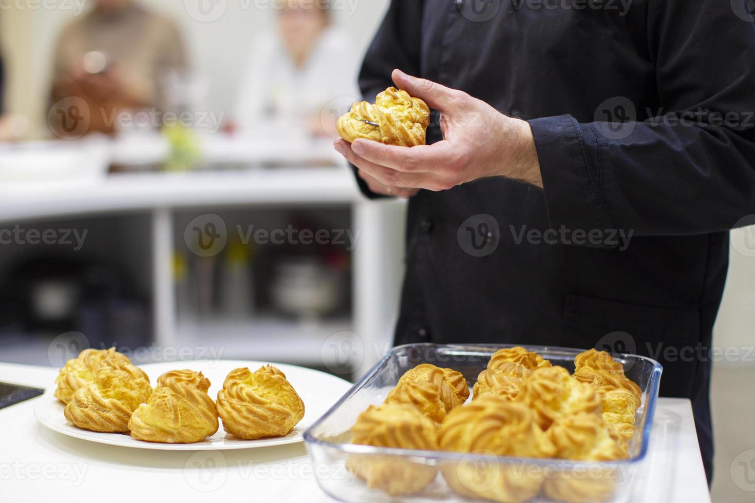 mãos cozinhar cozinhar éclairs. a processo do fazer bolo. foto