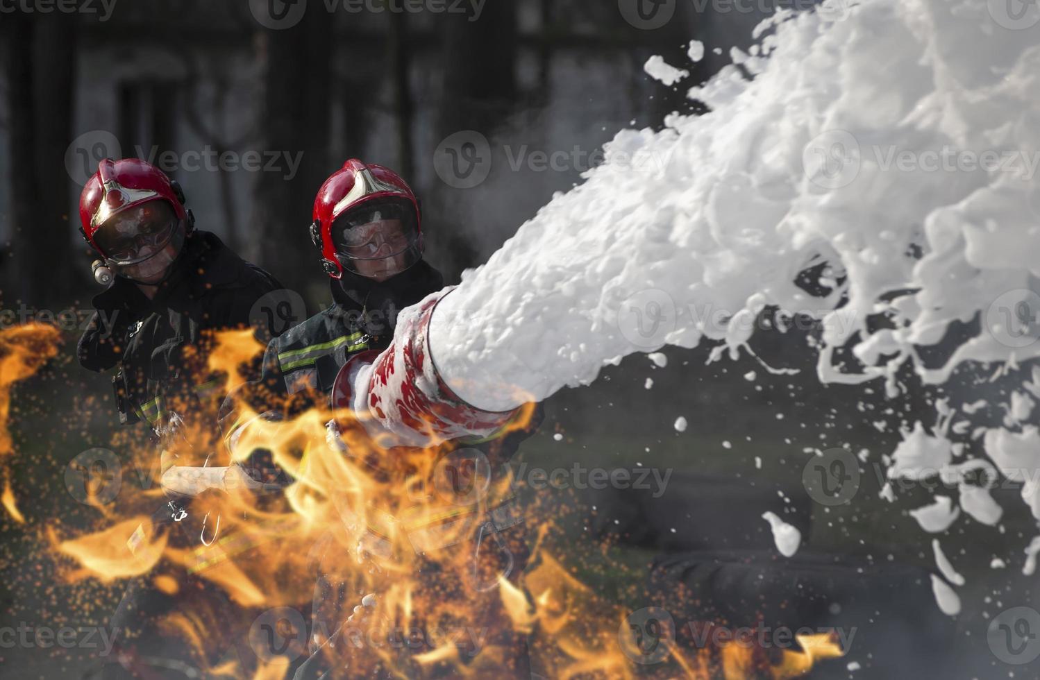 bombeiros extinguir uma fogo. salva-vidas com fogo mangueiras dentro fumaça e fogo. foto