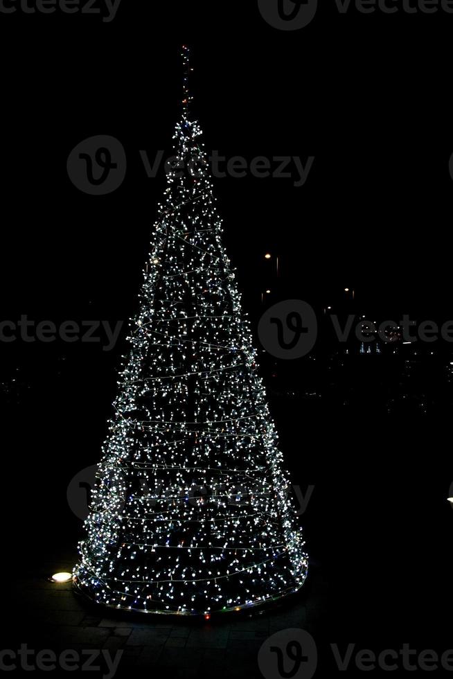 brilhando cidade decorações para Natal em uma Sombrio fundo foto