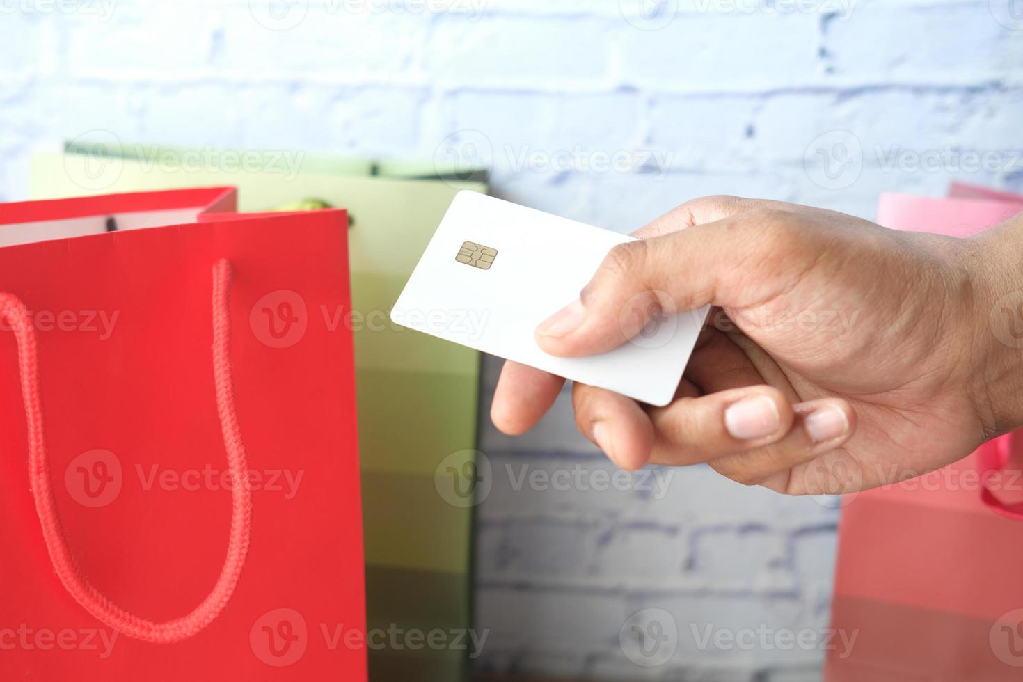 pessoa usando um cartão de crédito para comprar presentes foto
