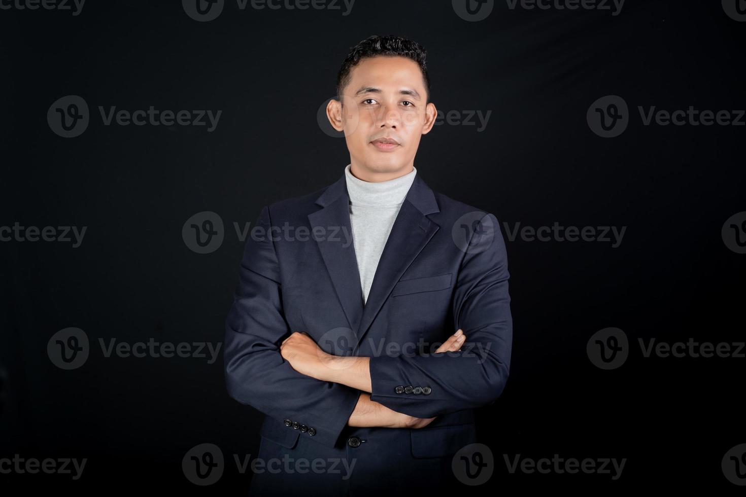 retrato do bonito elegante homem dentro Preto terno em Preto fundo. estúdio modo retrato foto