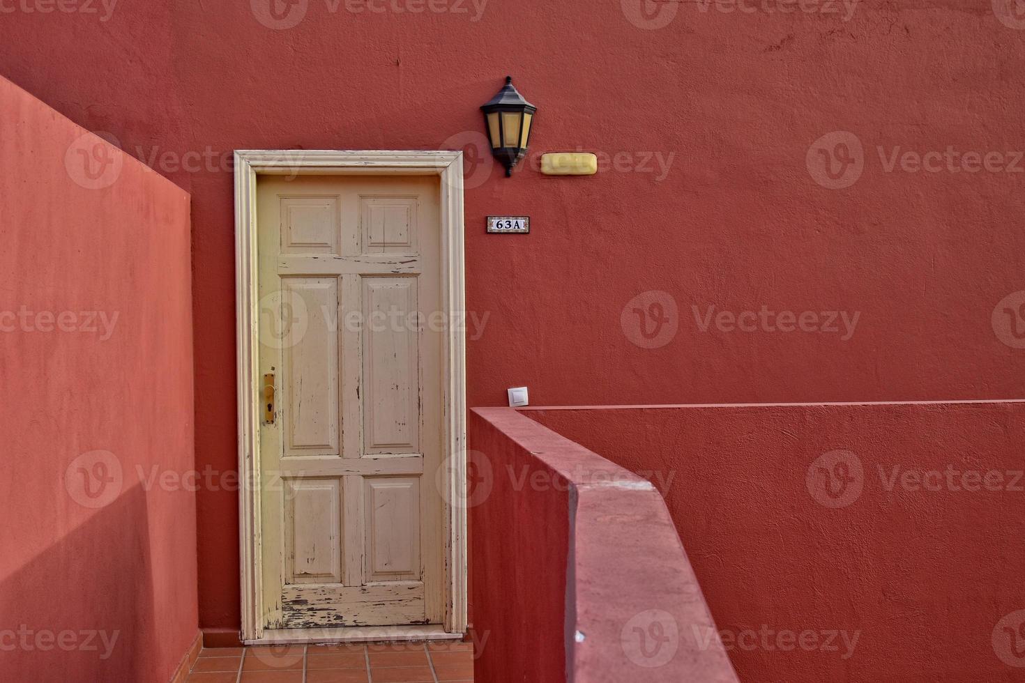 velho vintage Entrada porta em a fundo do vermelho parede foto