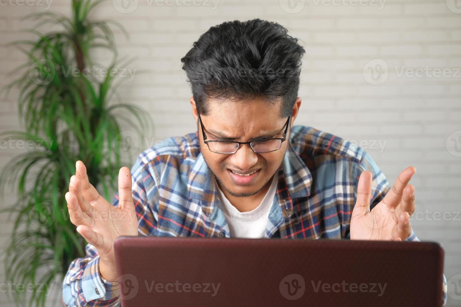 homem está confuso trabalhando no laptop foto