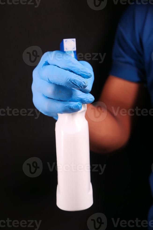 segurando um frasco de spray foto