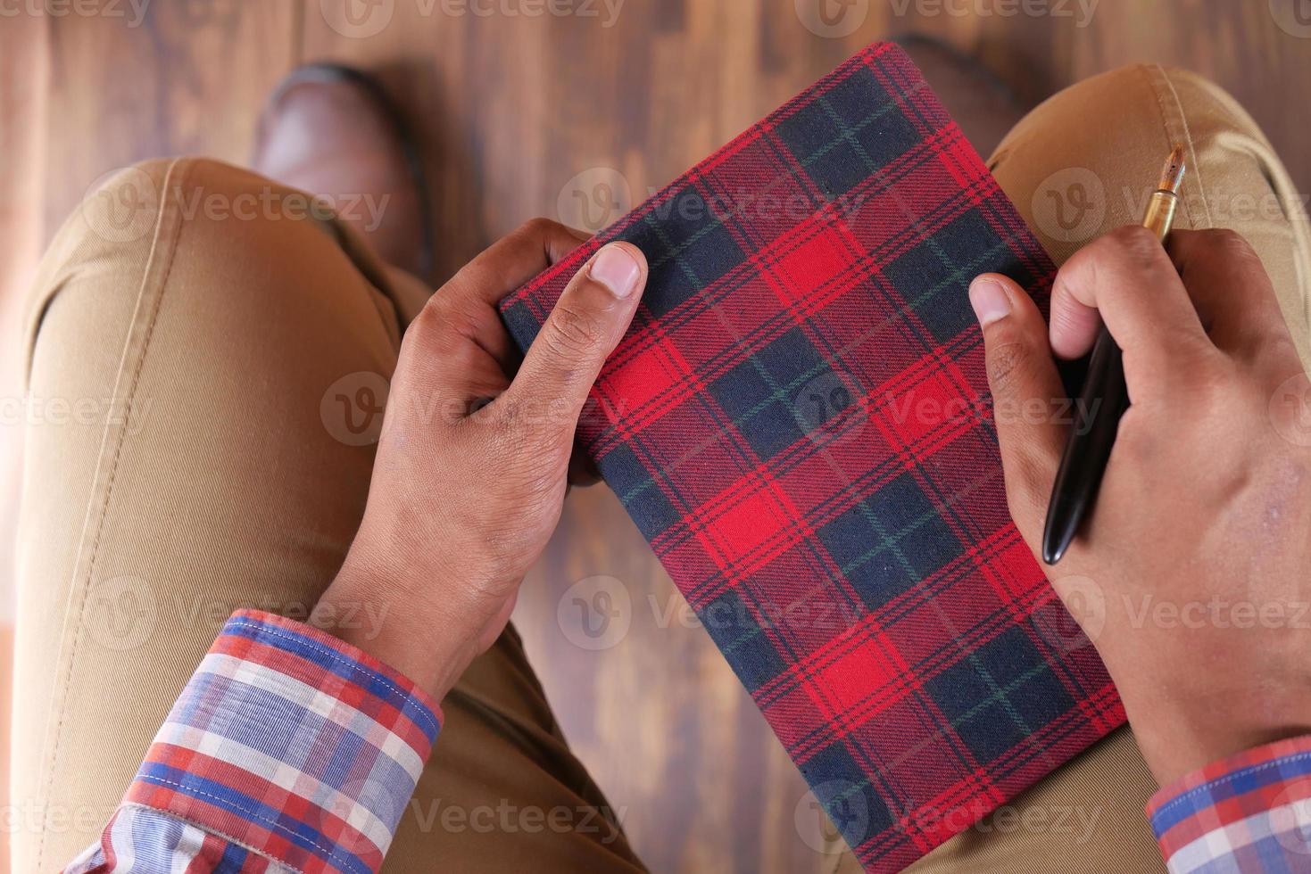 homem segurando caderno e caneta foto