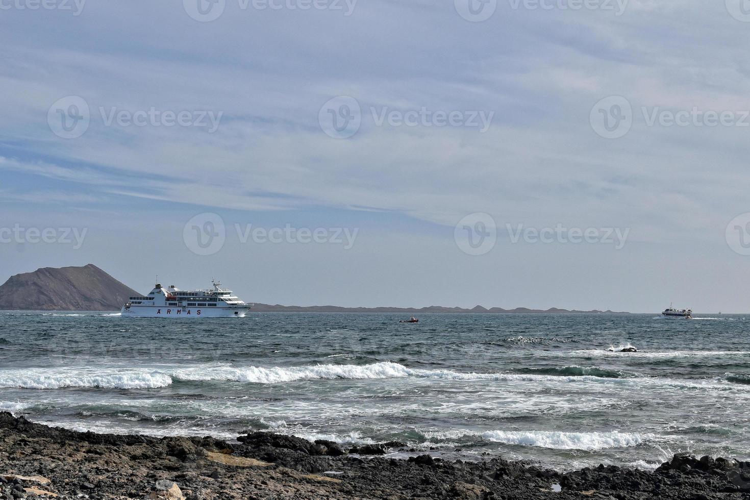 mar panorama com a oceano e uma Visão do a espanhol ilha do de Lobos com uma navio dentro a fundo foto