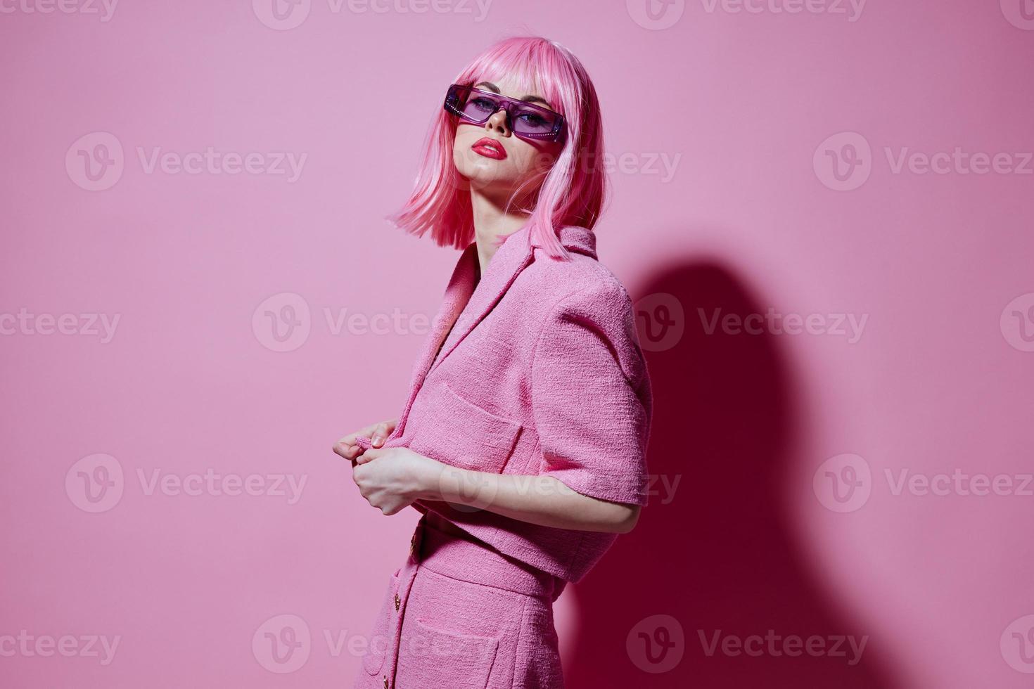 positivo jovem mulher gestos com dele mãos com uma Rosa Jaqueta Rosa fundo inalterado foto